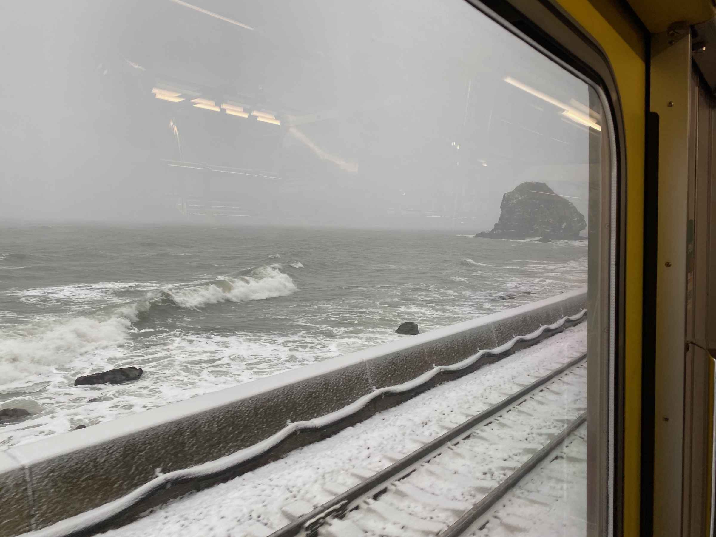 Photo of snow by the sea waves from a train