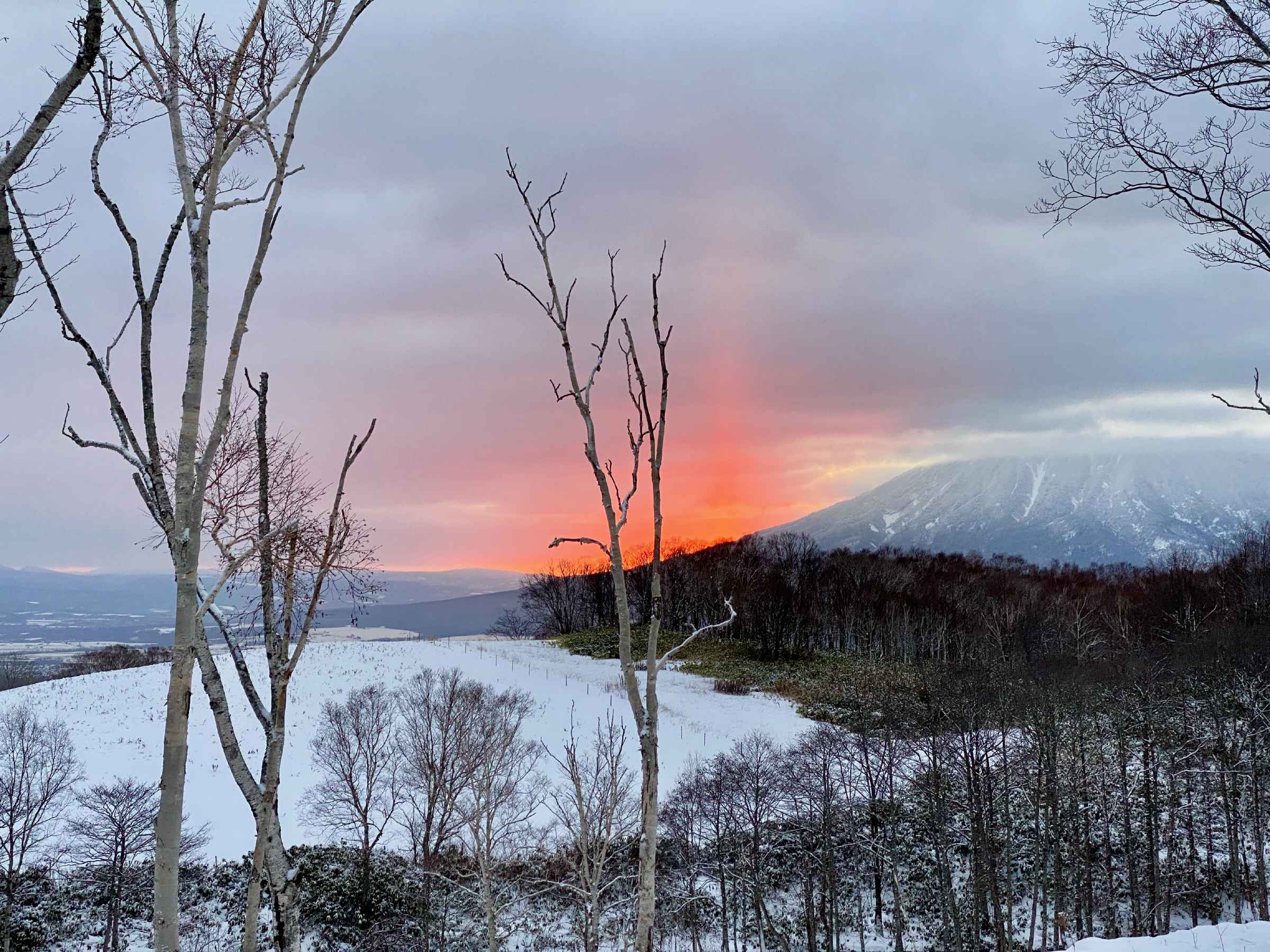 Photo of the sun rising from behind a nearby mountain
