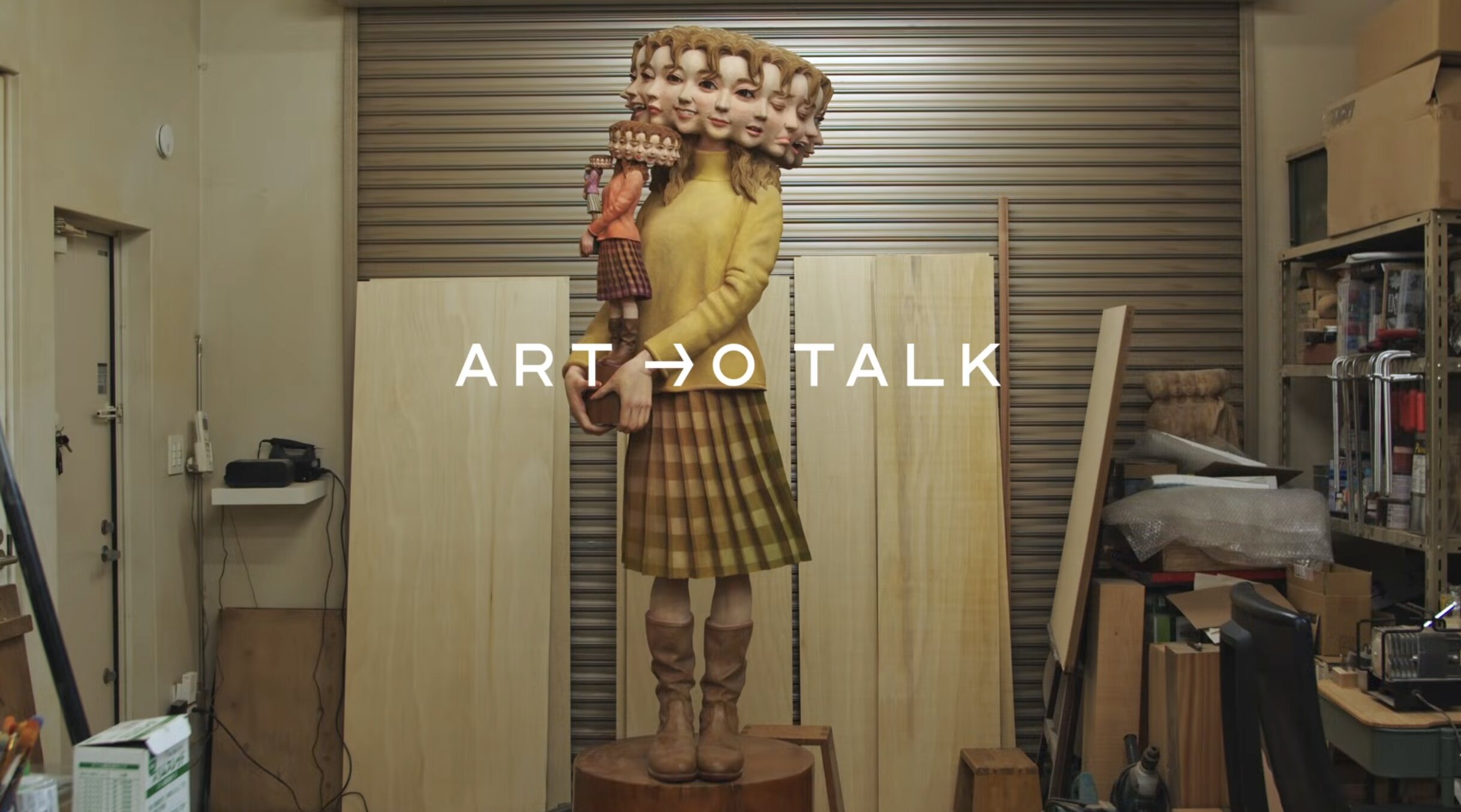 A wooden sculpture of a woman’s face that splits into sixteen overlapping faces when rotated